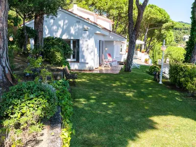 a small white house with a yard with trees at Holiday Home La Marina Blanca by Interhome in San Pol de Mar