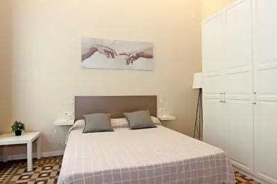 a bedroom with a bed with a checkered blanket at GIRONA - Modernist apartments next to Paseo de Gracia in Barcelona