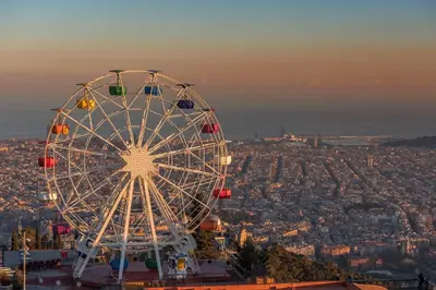 a ferris wheel sitting on top of a city at GIRONA - Modernist apartments next to Paseo de Gracia in Barcelona