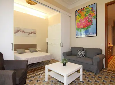 a living room with a bed and a couch at GIRONA - Modernist apartments next to Paseo de Gracia in Barcelona