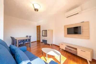 a living room with a blue couch and a table at HomeHolidaysRentals Elodie in Calella