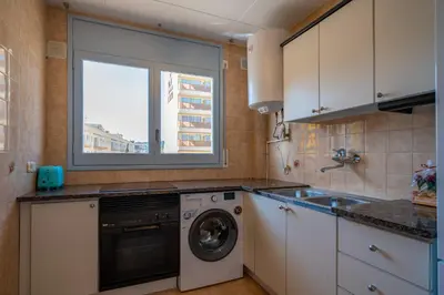a kitchen with a washing machine and a window at HomeHolidaysRentals Elodie in Calella