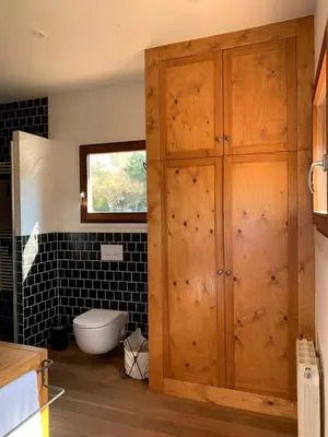 a bathroom with a toilet and a wooden cabinet at Cal Secretari in Rellinars