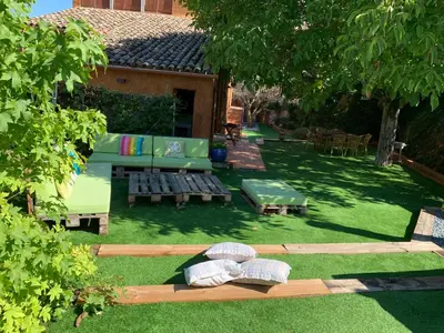 a backyard with a couch and benches and a table at Cal Secretari in Rellinars