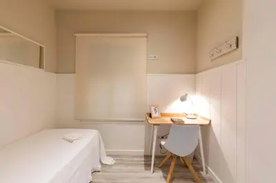 a bedroom with a desk and a bed and a table at Chic Gran Via Apartment in Barcelona