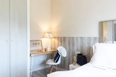 a bedroom with a bed and a desk with a chair at Chic Gran Via Apartment in Barcelona