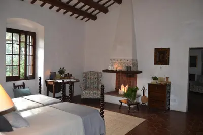 a bedroom with a bed and a fireplace at Mas Peirot Sitges in Cunit