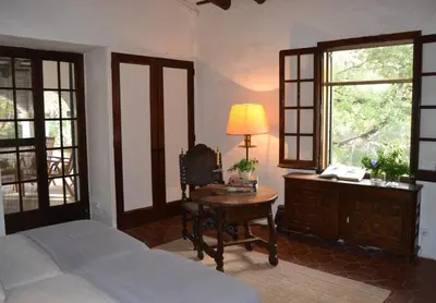 a bedroom with a bed and a desk with a lamp at Mas Peirot Sitges in Cunit