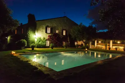 a swimming pool in front of a house at night at Mas Peirot Sitges in Cunit