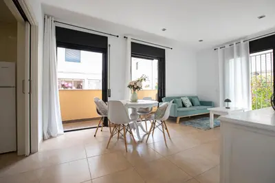 a living room with a blue couch and a chair at INASS in Sitges