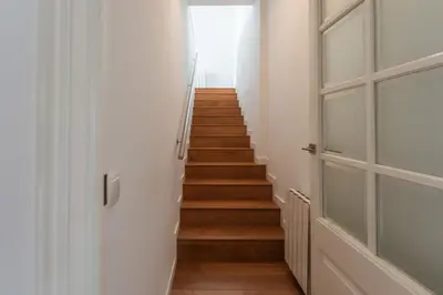a hallway with wooden stairs and a door at Beach Villa Cristina by HHBCN in Castelldefels