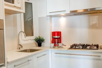 a kitchen with a sink and a red coffee maker at La Gioia 1 by Hello Homes Sitges in Sitges