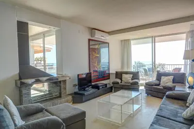 a living room with couches and a tv and a fireplace at La Gioia 2 by Hello Homes Sitges in Sitges