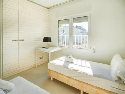 a white bedroom with a bed and a window at La Gioia 2 by Hello Homes Sitges in Sitges