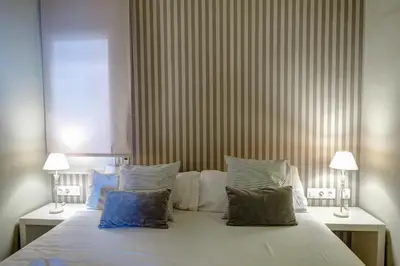 a bedroom with a large white bed with pillows at La Gioia 3 by Hello Homes Sitges in Sitges