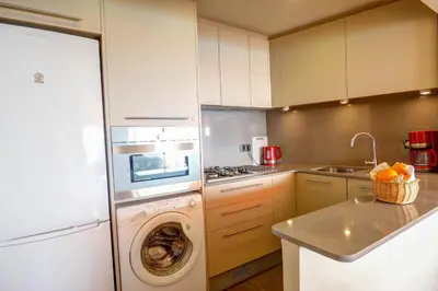 a kitchen with a washing machine and a washer at La Gioia 3 by Hello Homes Sitges in Sitges
