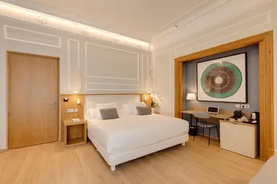 a bedroom with a large white bed and a desk at Hotel Boutique Mirlo Barcelona in Barcelona