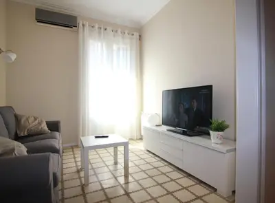 a living room with a tv and a couch and a table at CORSEGA - Apartment in the center of Barcelona in Barcelona