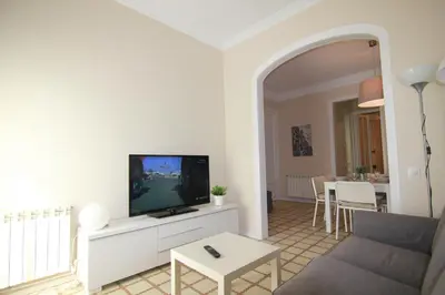 a living room with a couch and a tv and a table at CORSEGA - Apartment in the center of Barcelona in Barcelona