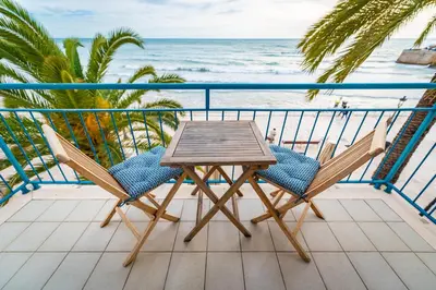 a table and chairs on a balcony overlooking the ocean at InSitges Sant Sebastia's Beach in Sitges