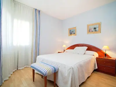 a bedroom with a bed and a chair and a window at Apartment Edificio Blanqueries by Interhome in Calella