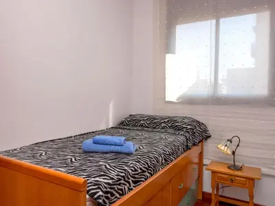 a small bedroom with a bed with a blue towel on it at Apartment Poblenou by Interhome in Barcelona