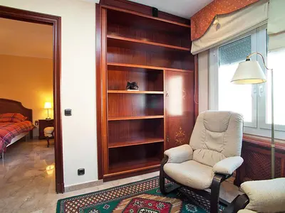 a living room with a chair and a bedroom at Apartment Pg Gracia - Valencia by Interhome in Barcelona
