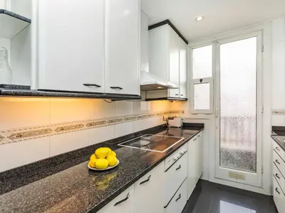 a kitchen with white cabinets and a plate of lemons on the counter at Apartment Sants-Les Corts Galileu by Interhome in Barcelona