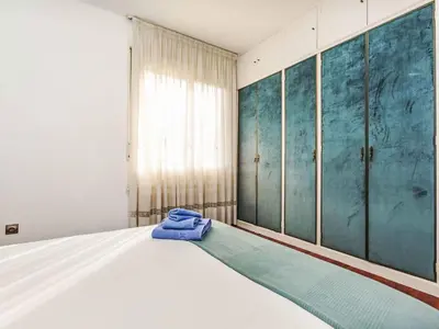 a bedroom with a white bed with blue walls at Apartment Sants-Les Corts Galileu by Interhome in Barcelona