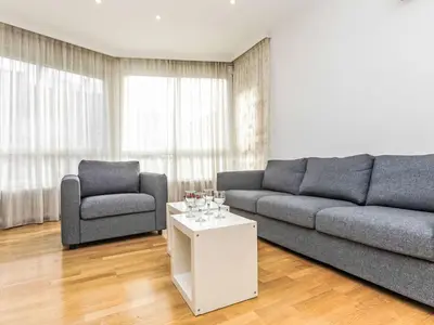 a living room with a couch and a chair and a table at Apartment Sants-Les Corts Galileu by Interhome in Barcelona