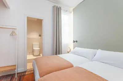 a bedroom with a bed and a bathroom with a toilet at Flateli Pelayo H5 in Barcelona