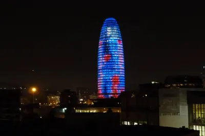 a building lit up in blue and red at night at Sunny Apt Barcelona 22 in Barcelona