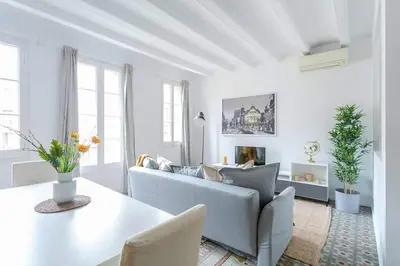 a white living room with a couch and a table at Exquisite&historic Flat With Rooftop in Barcelona