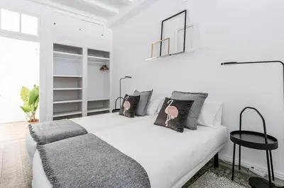 a white bedroom with a bed with pillows on it at Exquisite&historic Flat With Rooftop in Barcelona