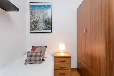 a bedroom with a bed and a lamp on a night stand at Vive Como Un Barcelons in Barcelona