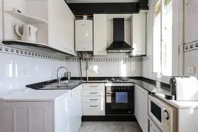 a white kitchen with a sink and a stove at Vive Como Un Barcelons in Barcelona