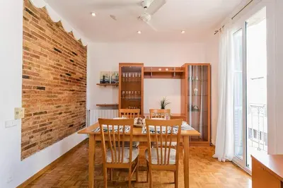 a dining room with a wooden table and chairs at Vive Como Un Barcelons in Barcelona