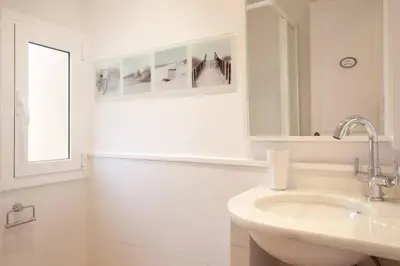 a white bathroom with a sink and a mirror at Apt In 22 Close To The Beach in Barcelona