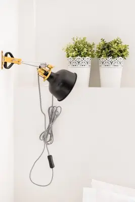 a lamp hanging on a wall with potted plants at Charming Apartment With Vibrant Accents in Hospitalet de Llobregat