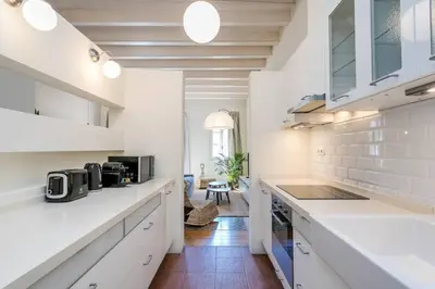 a kitchen with white cabinets and a counter top at Historical Apartment With Awesome Rooftop in Barcelona