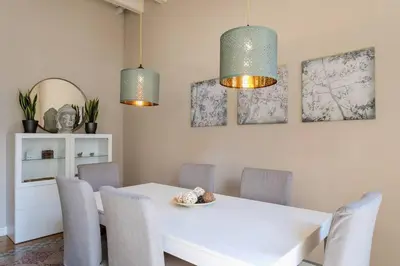 a dining room with a white table and chairs at Historical Apartment With Awesome Rooftop in Barcelona