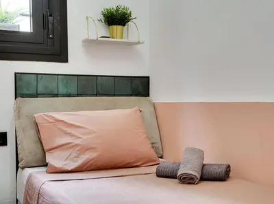 a bed with a pillow on top of it at Casa Maria Townhouse- terrace-4 bedrooms in Hospitalet de Llobregat