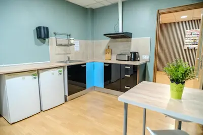a kitchen with a table and a blue wall at HolidaysBCN Rooms in Barcelona
