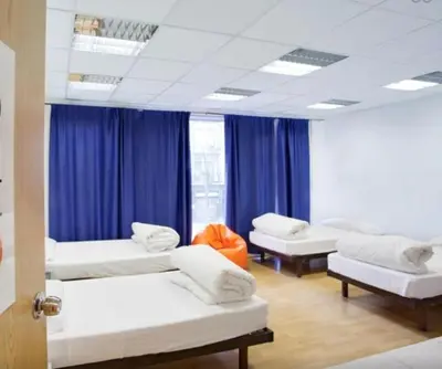 a hospital room with three beds and blue curtains at HolidaysBCN Rooms in Barcelona