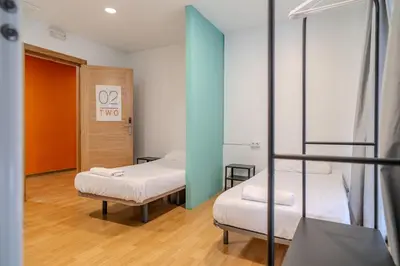 a room with two bunk beds and a doorway at HolidaysBCN Rooms in Barcelona