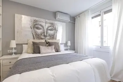 a bedroom with a large bed with a painting on the wall at Besos Beach Gem 1 By MyRentalHost in Sant Adria de Besos