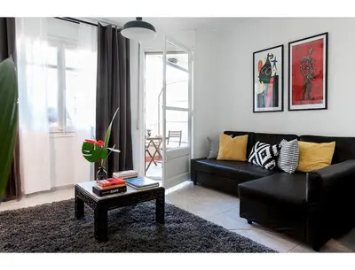 a living room with a black couch and a table at CENTRAL STYLISH EIXAMPLE - Casa Antonio By MyRentalHost in Barcelona