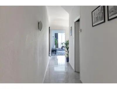a hallway with white walls and a doorway with a plant at CENTRAL STYLISH EIXAMPLE - Casa Antonio By MyRentalHost in Barcelona