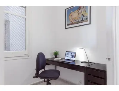 a desk with a laptop and a chair in a room at CENTRAL STYLISH EIXAMPLE - Casa Antonio By MyRentalHost in Barcelona