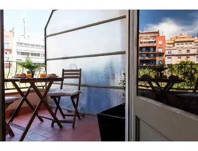 a balcony with a table and chairs and a window at CENTRAL STYLISH EIXAMPLE - Casa Antonio By MyRentalHost in Barcelona